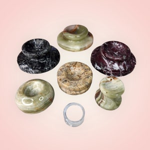 May include: Seven different marble coasters in various colors and patterns. The coasters are round and have a raised edge. They are made of natural stone and have a unique, handcrafted look.