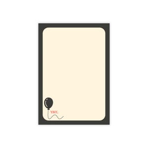 May include: A rectangular notepad with a black border and a cream-coloured interior. A black balloon graphic is in the lower left corner, with the word "YAY" in pink below it. The notepad is blank.