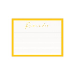 May include: A rectangular notepad with a bright yellow border. The notepad has a white interior with horizontal lines and the word "Reminder" in gold script at the top. The notepad is designed for jotting down notes.