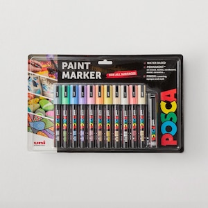 Puede incluir: Un juego de doce marcadores de pintura Uni Posca en un paquete blíster. Los marcadores tienen cuerpos negros con tapas de colores y están etiquetados para todas las superficies. El empaque presenta el texto Paint Marker, Posca y detalles.