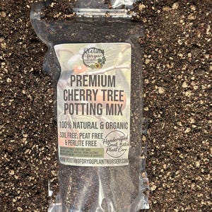 May include: A clear plastic bag filled with a dark brown potting mix for cherry trees. The bag has a white label with the text "Rooting for you Plant Nursery" and "Premium Cherry Tree Potting Mix". The label also states that the mix is 100% natural and organic, soil free, peat free, and perlite free. It is handcrafted in small batches.