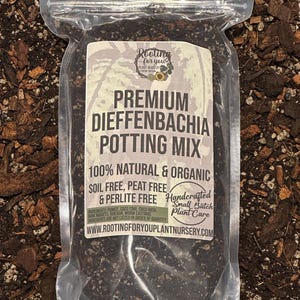 May include: A clear plastic bag filled with a dark brown potting mix for Dieffenbachia plants. The bag has a white label with the text "Rooting for you Plant Nursery", "Premium Dieffenbachia Potting Mix", "100% Natural & Organic", "Soil Free, Peat Free & Perlite Free", "Handcrafted Small Batch Plant Care", and "www.rootingforyouplantnursery.com".