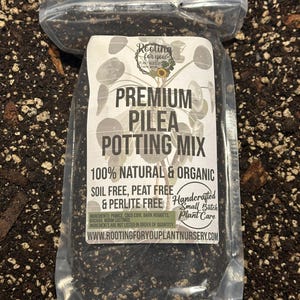 May include: A white bag of premium Pilea potting mix, labeled "Rooting for you Plant Nursery." The bag is 100% natural and organic, soil-free, peat-free, and perlite-free. The ingredients include pumice, coco coir, bark nuggets, biochar, and worm castings. The bag is handcrafted in small batches with plant care in mind.