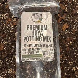 May include: A clear plastic bag filled with a dark brown potting mix for Hoya plants. The bag has a white label with the text "Rooting for you Plant Nursery", "Premium Hoya Potting Mix", "100% Natural & Organic", "Soil Free, Peat Free & Perlite Free", "Handcrafted Small Batch Plant Care", and "www.rootingforyouplantnursery.com".