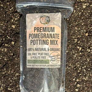 May include: A clear plastic bag filled with a dark brown potting mix. The bag has a label that reads "Premium Pomegranate Potting Mix" and "100% Natural & Organic Soil Free, Peat Free & Perlite Free". The label also states "Handcrafted Small Batch Plant Care" and includes the website address "www.rootingforyouplantnursery.com".