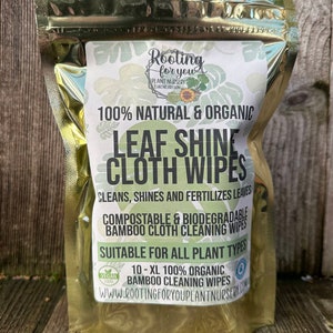 May include: A gold foil pouch with a label that reads "Rooting for you Plant Nursery Eugene, Oregon". The label also says "100% Natural & Organic Leaf Shine Cloth Wipes", "Cleans, Shines and Fertilizes Leaves", "Compostable & Biodegradable Bamboo Cloth Cleaning Wipes", "Suitable for All Plant Types", "10-XL 100% Organic Bamboo Cleaning Wipes", and "www.rootingforyouplantnursery.com".