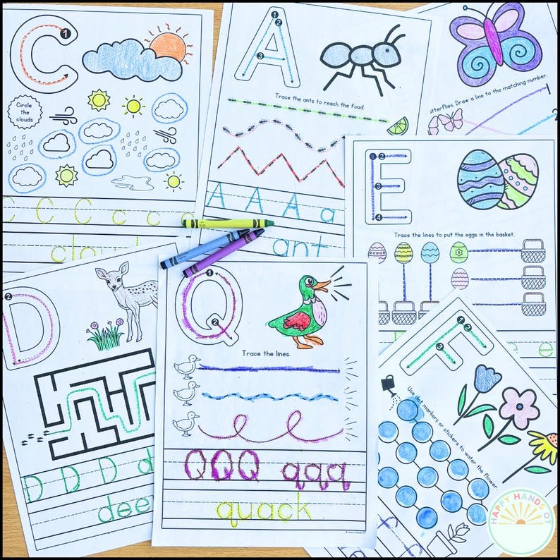 May include: A set of children's educational worksheets with alphabet letters, tracing exercises, and colouring activities. The pages feature illustrations of a cloud, sun, ant, butterfly, duck, and flowers, with crayons on top.