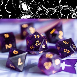 Puede incluir: Un conjunto de seis dados morados con números dorados. Los dados están sobre una superficie con un patrón morado y blanco.