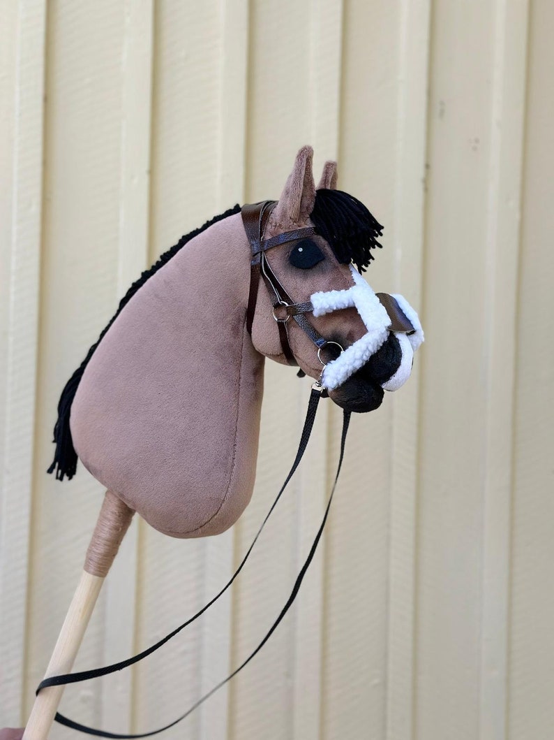 Peut inclure: Un cheval en bois brun et noir avec un nez en polaire blanc et des r&ecirc;nes noires. Le cheval a une crini&egrave;re et une queue noires.