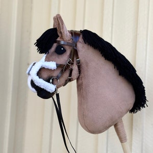 Peut inclure: Une t&ecirc;te de cheval marron et blanche avec une crini&egrave;re noire et une bride en cuir marron. La t&ecirc;te de cheval est fix&eacute;e &agrave; un b&acirc;ton en bois.