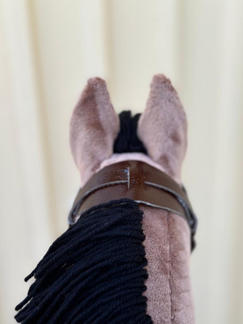 Peut inclure: Un jouet en peluche en forme de cheval brun avec une crini&egrave;re et une queue noires. Le cheval porte un bridon en cuir brun avec une boucle.