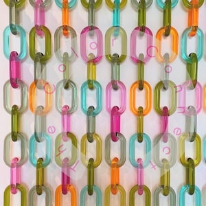 May include: A colorful, abstract art piece featuring rows of translucent, oval-shaped links in various colors, including green, pink, orange, and blue. The links are connected vertically, creating a chain-like pattern against a white background.