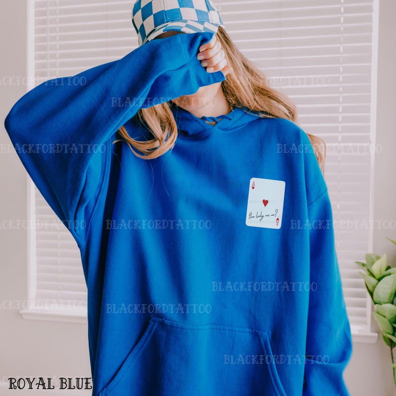 Puede incluir: Sudadera con capucha azul real con un dise&ntilde;o de tarjeta blanca con un coraz&oacute;n rojo y el texto "The lady is me?"