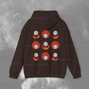 May include: A brown hoodie with a pattern of eight-ball pool balls with flames on a red and white checkered background.