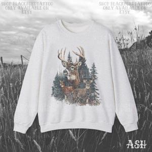 May include: Ash-coloured sweatshirt with a detailed graphic of a buck with large antlers and several deer in a forest setting. The text "SHOP BLACKFORDTATTOO ONLY AVAILABLE ON ETSY" is printed at the top. The word "ASH" is printed at the bottom right.