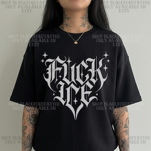 May include: Black t-shirt with a white gothic-style graphic that reads "Fuck Me" in a heart shape. The shirt has short sleeves and a relaxed fit. The text "SHOP BLACKFORDTATTOO ONLY AVAILABLE ON ETSY" is printed around the shirt.