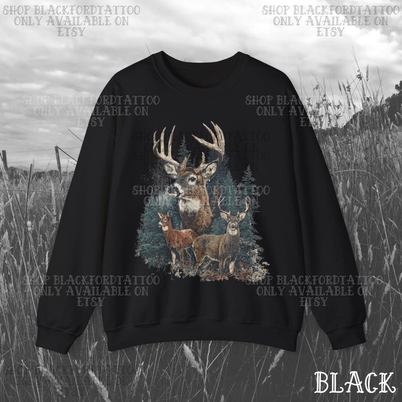 May include: Black sweatshirt with a detailed illustration of deer in a forest. The design features a large buck with antlers, two smaller deer, and evergreen trees. The word "BLACK" is at the bottom right.