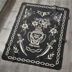 Op de afbeelding: Zwarte deken met een crèmekleurig tattoo-achtig ontwerp. Het ontwerp omvat vlinders, bloemen, een vaas, dolken en schakels. De rand van de deken is een schakelpatroon. De tekst "SHOP BLACKFORDTATTOO ONLY AVAILABLE ON ETSY".