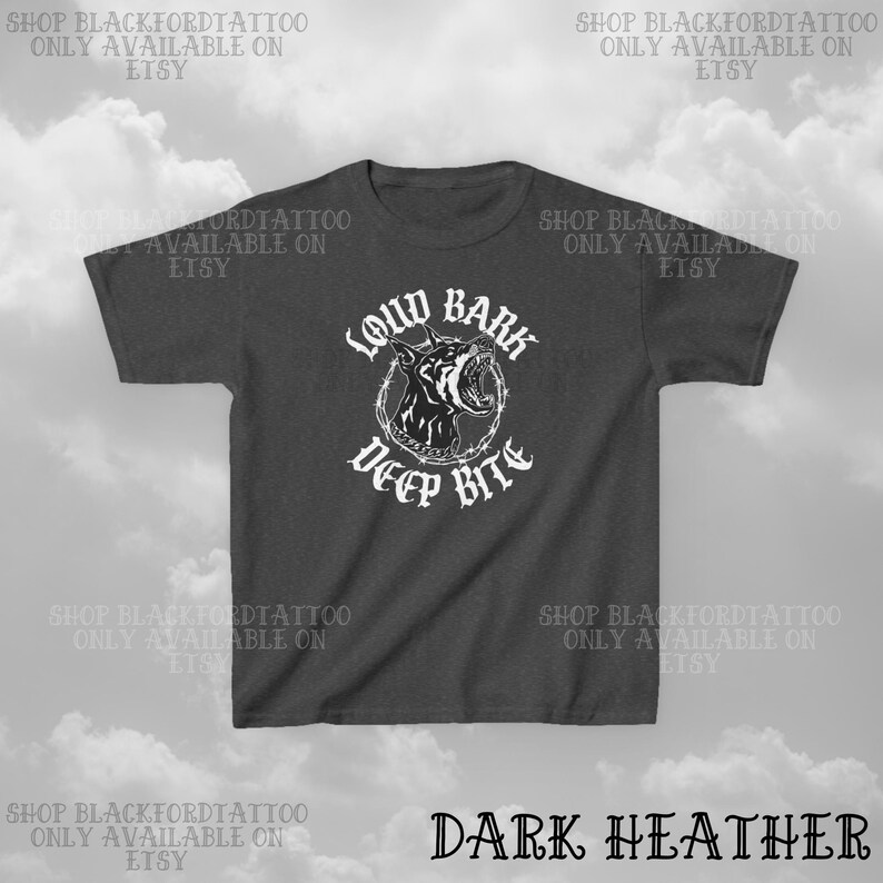 Puede incluir: Camiseta gris oscuro con un gr&aacute;fico blanco de la cabeza de un perro gru&ntilde;endo dentro de un c&iacute;rculo de alambre de p&uacute;as. El texto "LOUD BARK DEEP BITE" est&aacute; debajo. El texto "DARK HEATHER" est&aacute; en la parte inferior.