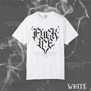 May include: White t-shirt with a black gothic-style heart-shaped graphic that reads "FUCK ME". The shirt also has text that says "SHOP BLACKFORDTATTOO ONLY AVAILABLE ON ETSY" in a repeating pattern. The word "WHITE" is in the bottom right corner.