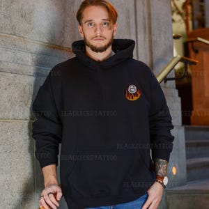 May include: A black hooded sweatshirt with a white 8-ball graphic with flames on a black background.