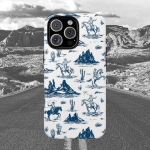 Op de afbeelding: Witte telefoonhoes met een blauw en wit patroon van cowboys die op paarden rijden en cactussen. De hoes heeft een uitsparing voor de cameralens.