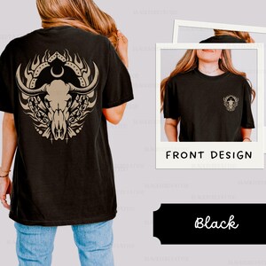 Puede incluir: Camiseta negra con un dise&ntilde;o de calavera y huesos cruzados en la espalda y una versi&oacute;n m&aacute;s peque&ntilde;a del dise&ntilde;o en la parte delantera. El texto "FRONT DESIGN" est&aacute; impreso en la parte delantera de la camiseta.