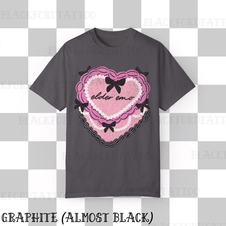 May include: Graphite-colored t-shirt featuring a pink heart-shaped design with the words "elder emo." The heart is decorated with black bows and a black lace border. The shirt's color is described as "almost black."