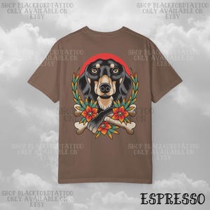 K&ouml;nnte beinhalten: Espressofarbenes T-Shirt mit einer Hundeillustration mit rotem Kreis, Lorbeerkranz, Blumen und gekreuzten Knochen. Der Text "SHOP BLACKFORDTATTOO ONLY AVAILABLE ON ETSY" ist um das Design herum gedruckt.