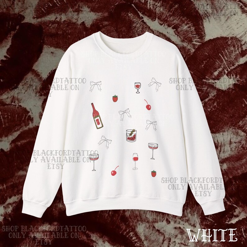 May include: White sweatshirt with a scattered pattern of wine glasses, bows, cherries, strawberries, and a wine bottle. The text "WHITE" is at the bottom right. The words "BLACKFORDTATTOO ONLY AVAILABLE ON ETSY" are printed on the sweatshirt.