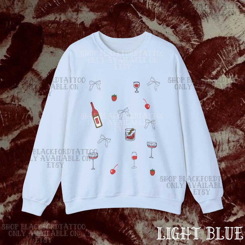 May include: Light blue sweatshirt with a pattern of wine bottles, glasses, cherries, strawberries, and bows. The text "SHOP BLACKFORDTATTOO ONLY AVAILABLE ON ETSY" is printed on the sweatshirt.