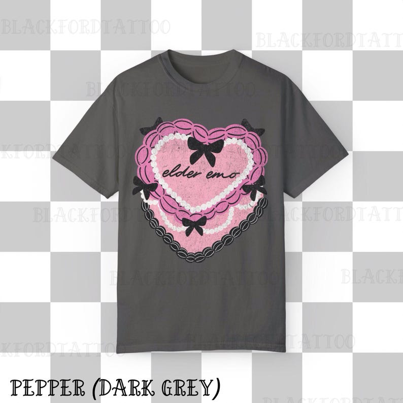 May include: Dark grey t-shirt featuring a pink heart-shaped graphic with the text "elder emo". The graphic includes black bows and a lace-like border. The shirt's color is described as "Pepper (Dark Grey)".