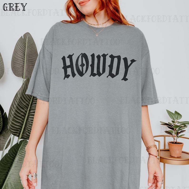 May include: A gray oversized t-shirt with the word "HOWDY" printed in black gothic lettering.