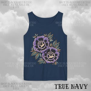 May include: A navy blue tank top featuring a floral design of two purple roses with green leaves and orange accents. The text "TRUE NAVY" is at the bottom. The top has the text "SHOP BLACKFORDTATTOO ONLY AVAILABLE ON ETSY" repeated around the top.