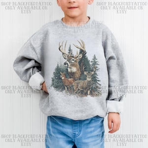 Puede incluir: Una sudadera gris con una ilustración detallada de ciervos en un bosque. El diseño incluye un ciervo con grandes astas, otros dos ciervos y árboles de hoja perenne. El texto "SHOP BLACKFORDTATTOO ONLY AVAILABLE ON ETSY" está impreso alrededor de la imagen.
