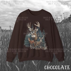 May include: A chocolate brown sweatshirt with a detailed graphic of deer in a forest. The design features a buck with large antlers, two smaller deer, and evergreen trees. The word "CHOCOLATE" is at the bottom.