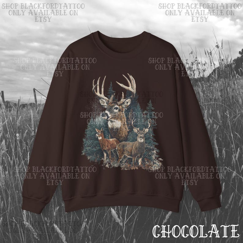 May include: A chocolate brown sweatshirt with a detailed graphic of deer in a forest. The design features a buck with large antlers, two smaller deer, and evergreen trees. The word "CHOCOLATE" is at the bottom.