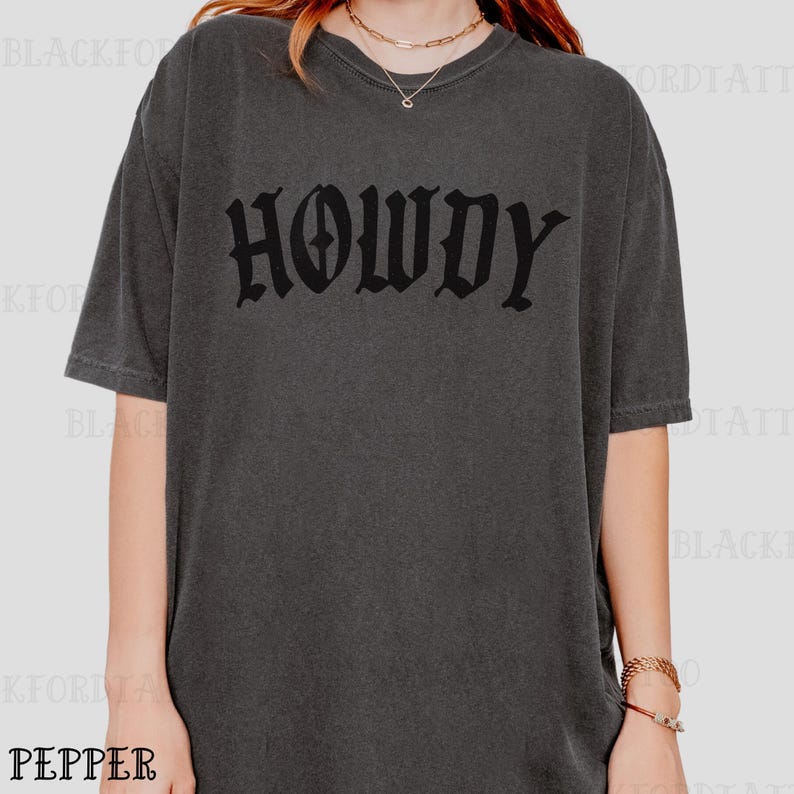 May include: A dark gray oversized t-shirt with the word "HOWDY" printed in black gothic lettering.