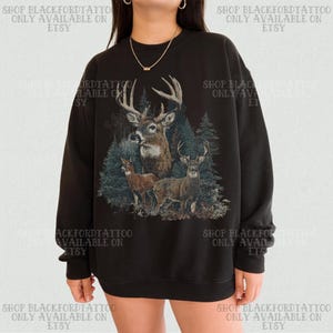 May include: Black sweatshirt with a detailed illustration of three deer in a forest. The design includes a buck with large antlers and two smaller deer. Text on the sweatshirt reads "SHOP BLACKFORDTATTOO ONLY AVAILABLE ON ETSY."