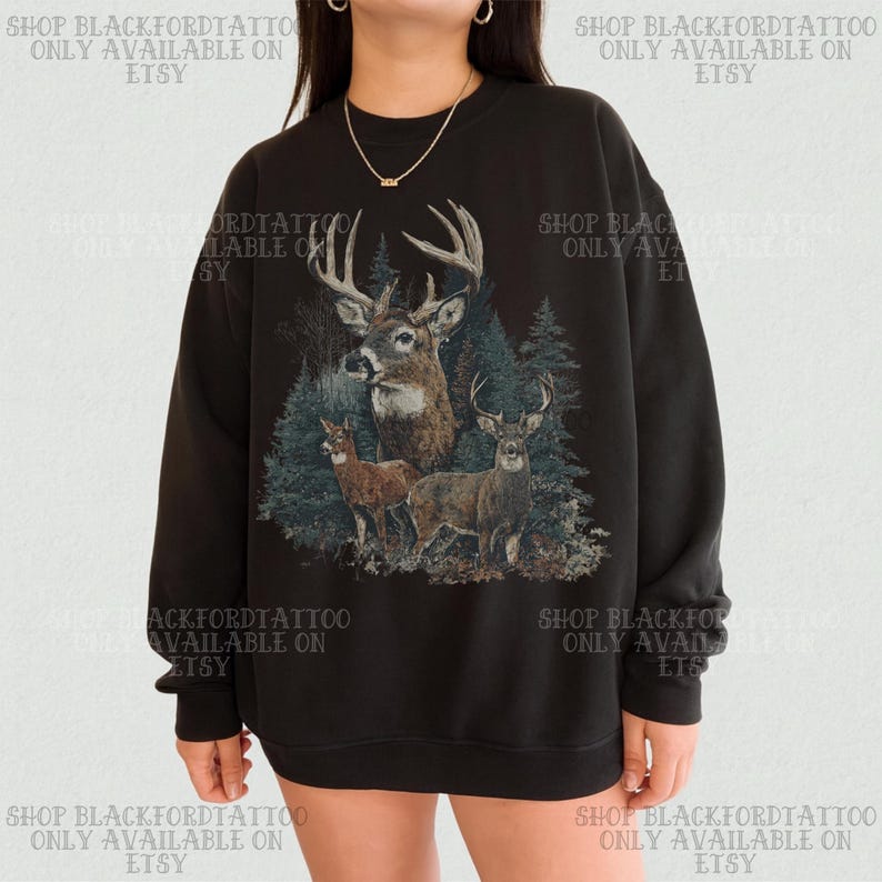 May include: Black sweatshirt with a detailed illustration of three deer in a forest. The design includes a buck with large antlers and two smaller deer. Text on the sweatshirt reads "SHOP BLACKFORDTATTOO ONLY AVAILABLE ON ETSY."