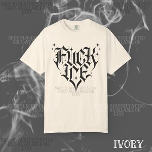 May include: Ivory-colored t-shirt featuring a black gothic heart design with the words "FUCK ME". The shirt has a crew neck and short sleeves. The text "SHOP BLACKFORDTATTOO ONLY AVAILABLE ON ETSY" is printed around the shirt.