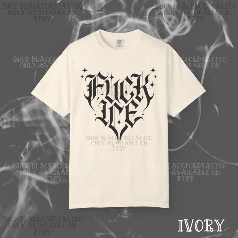 May include: Ivory-colored t-shirt featuring a black gothic heart design with the words "FUCK ME". The shirt has a crew neck and short sleeves. The text "SHOP BLACKFORDTATTOO ONLY AVAILABLE ON ETSY" is printed around the shirt.