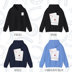 Puede incluir: Cuatro sudaderas con capucha en diferentes colores: negro, azul marino y azul claro. Cada sudadera presenta un gr&aacute;fico de dos cartas de juego con el texto "How lucky are we?" en la parte posterior.