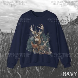 May include: Navy blue sweatshirt with a deer illustration set in a forest. The design shows a buck with large antlers, two smaller deer, and evergreen trees. The word "NAVY" is at the bottom right. Text on the top and sides reads "SHOP BLACKFORDTATTOO ONLY AVAILABLE ON ETSY."