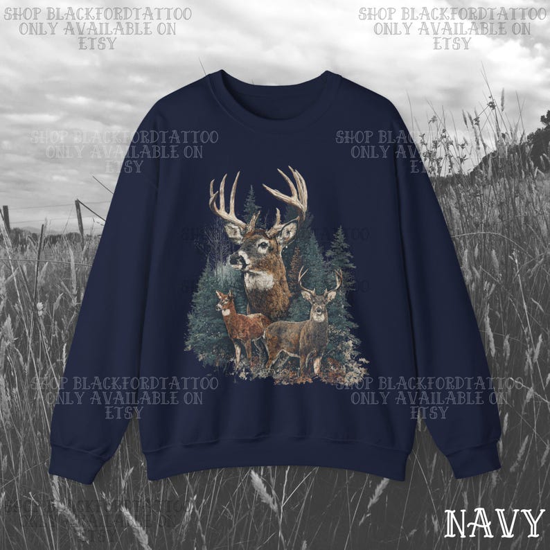 May include: Navy blue sweatshirt with a deer illustration set in a forest. The design shows a buck with large antlers, two smaller deer, and evergreen trees. The word "NAVY" is at the bottom right. Text on the top and sides reads "SHOP BLACKFORDTATTOO ONLY AVAILABLE ON ETSY."
