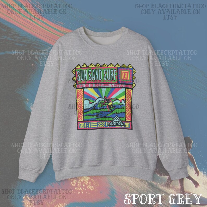 May include: Sport grey sweatshirt with a colorful graphic that reads "Sun Sand Surf." The graphic features a surfer, waves, and a rainbow. The sweatshirt has a crew neck and long sleeves.