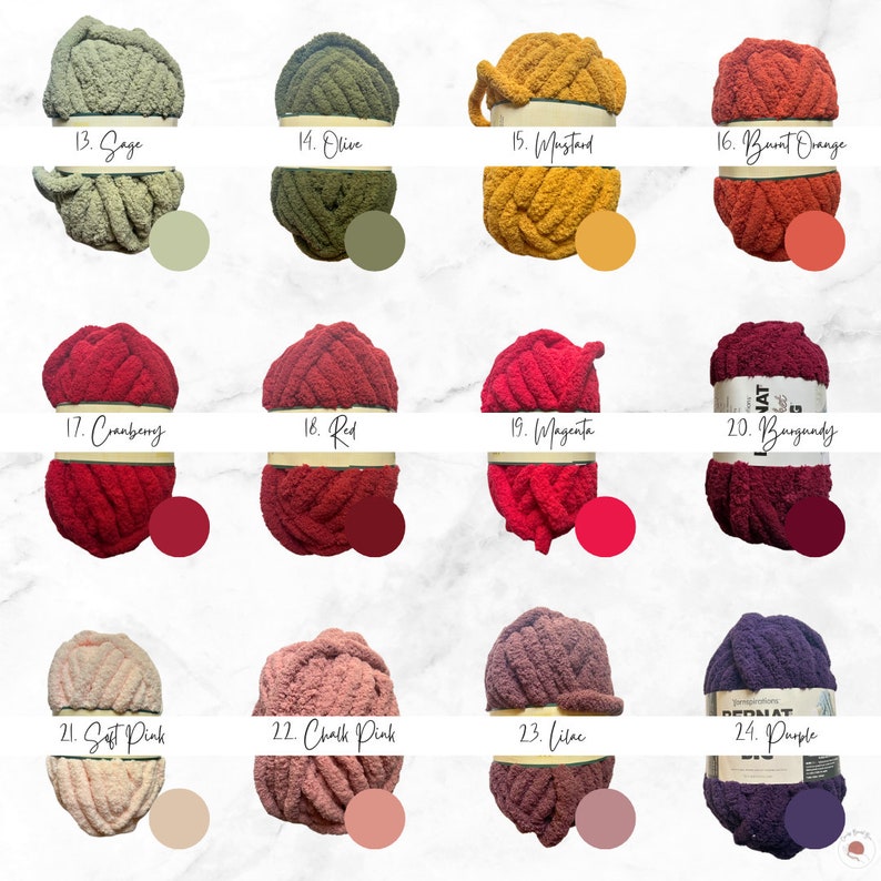 K&ouml;nnte beinhalten: Eine Auswahl an Bernat-Garnen in verschiedenen Farben, darunter Salbei, Olive, Senf, gebranntes Orange, Cranberry, Rot, Magenta, Burgunder, Zartrosa, Kreide-Rosa, Flieder und Lila. Jede Garnrolle ist mit ihrem Farbnamen und ihrer Nummer versehen.