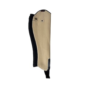 May include: Beige and black riding gaiters with a snap closure and a strap at the bottom.