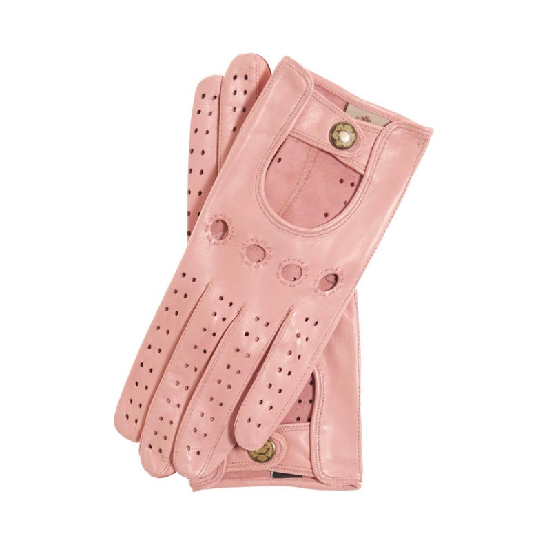 May include: A pair of light pink leather driving gloves featuring perforated detailing across the fingers and back of the hand. The gloves include a cutout design on the back, a snap button closure at the wrist, and a small metallic accent button.
