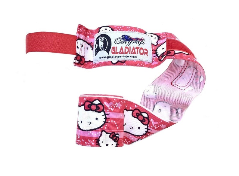 May include: Pink and white hand wraps with a Hello Kitty design. The wraps have a red strap and a label that reads "Omnyrafi Gladiator" with the website "www.gladiator-polo.com".